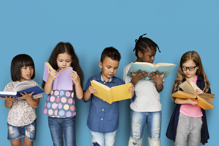 Children looking at books in front of a blue background